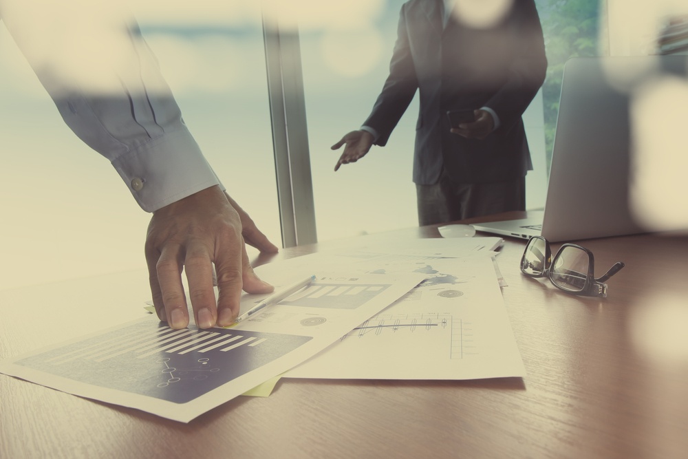 Double exposure of businessman hand working with new modern computer and business strategy as concept